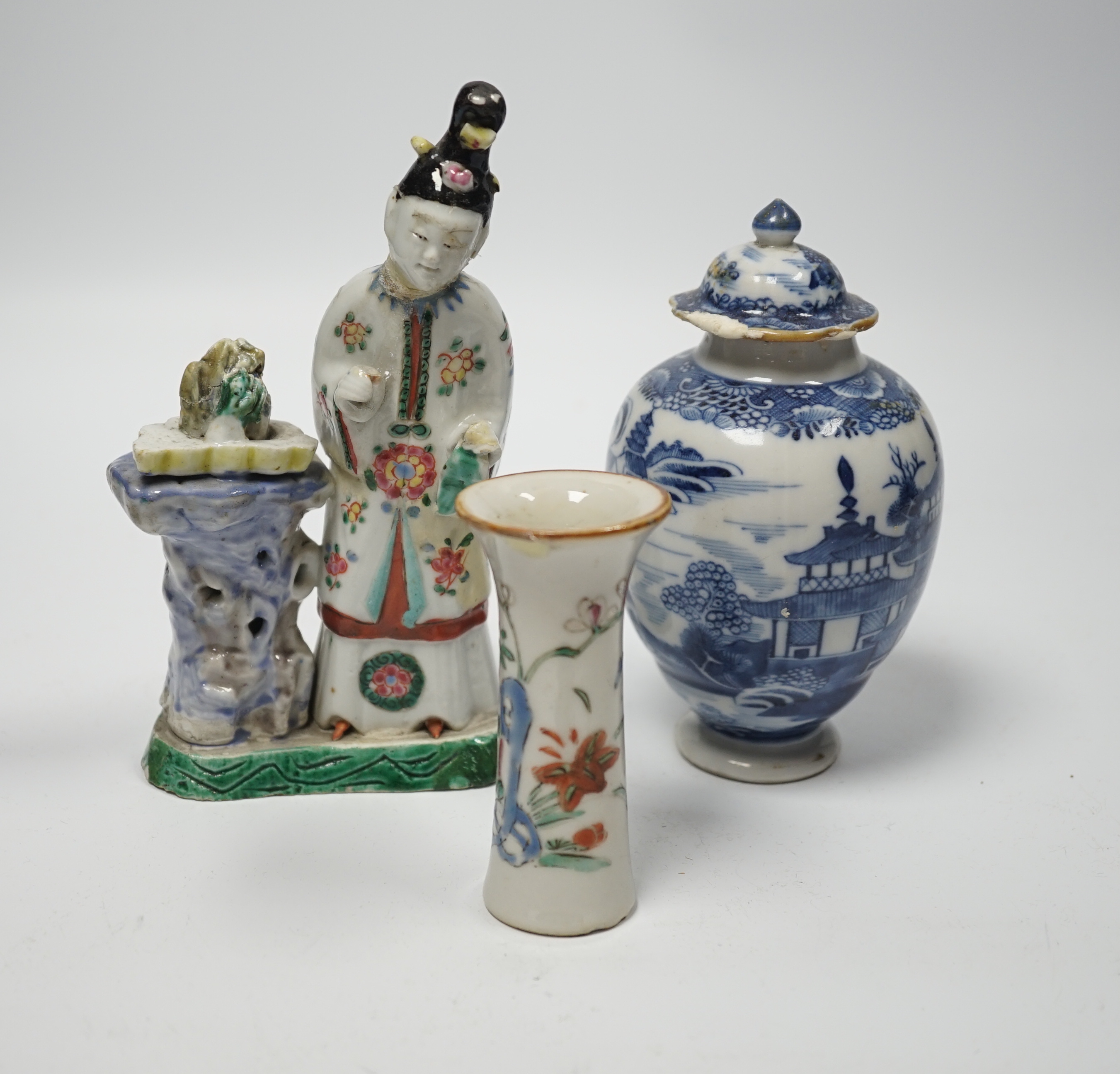 An 18th century Chinese enamelled porcelain figure of a lady standing by rockwork, a similar miniature vase and a blue and white tea caddy and cover, largest 17cm high